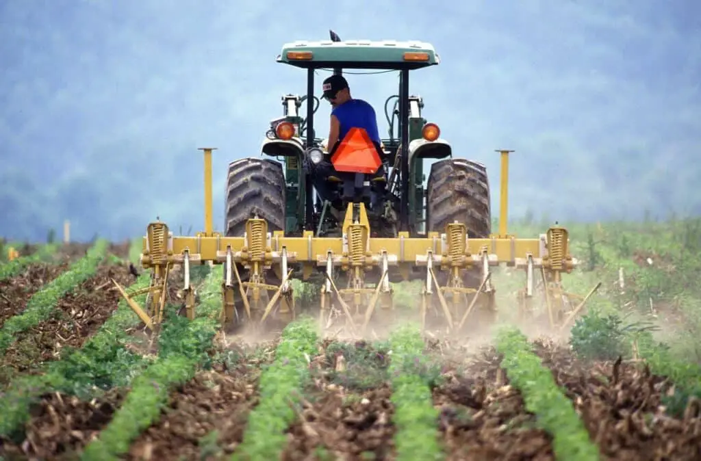 Man riding operating a tractor in the farm