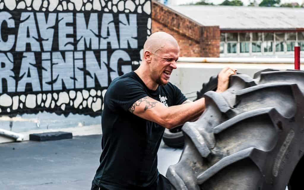 Bald man flipping a tire