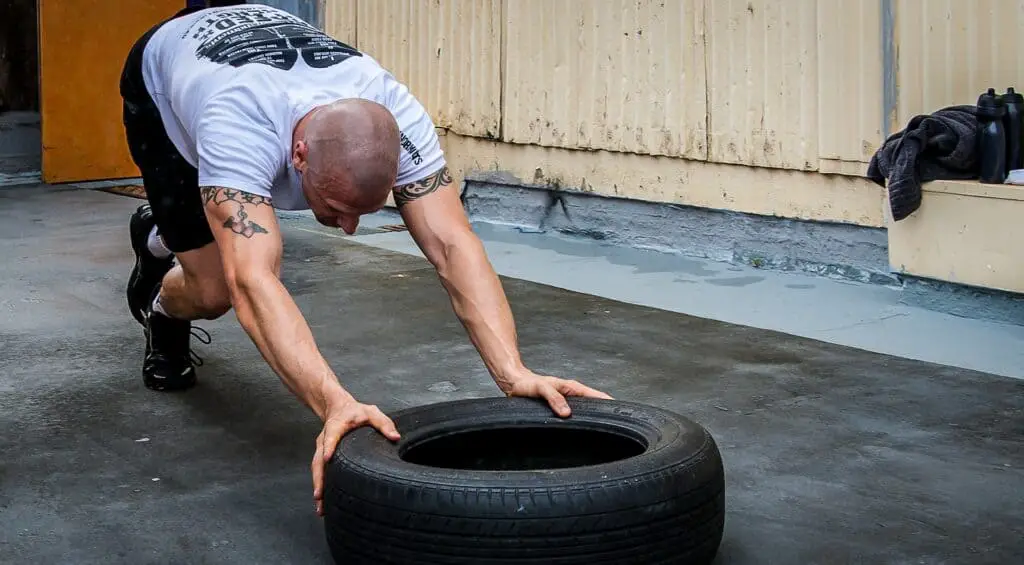 Man pushing a tire