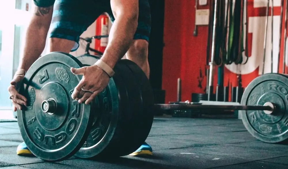 Man placing weight on a barbell