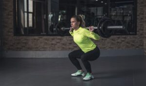 Woman squatting using a barbell