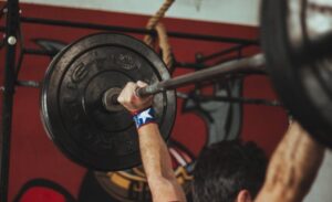 person lifting a black barbell